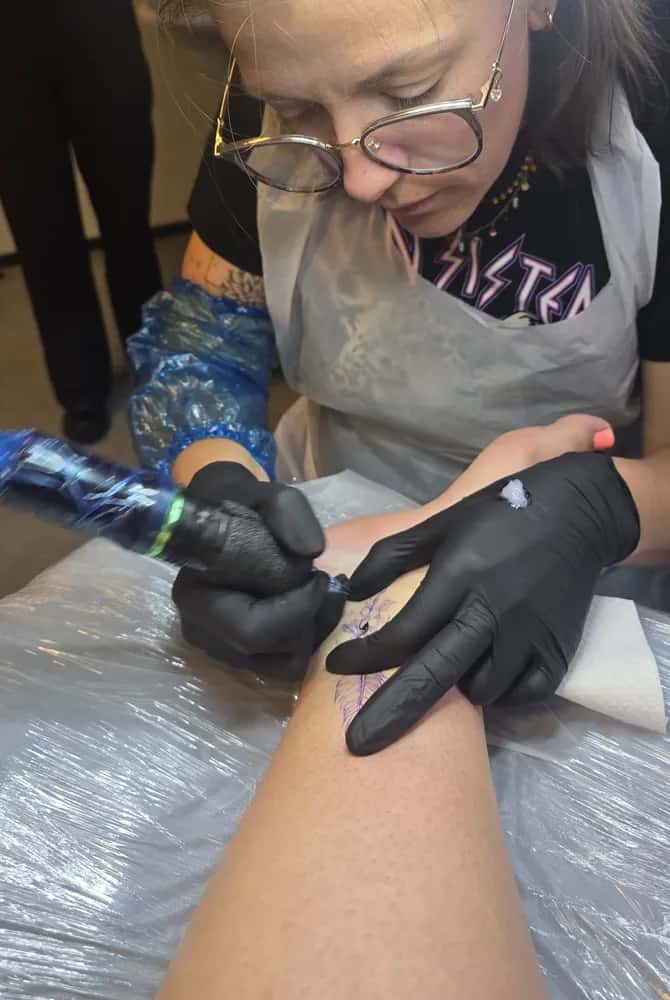 Marre geconcentreerd aan het werk tijdens het zetten van een tattoo