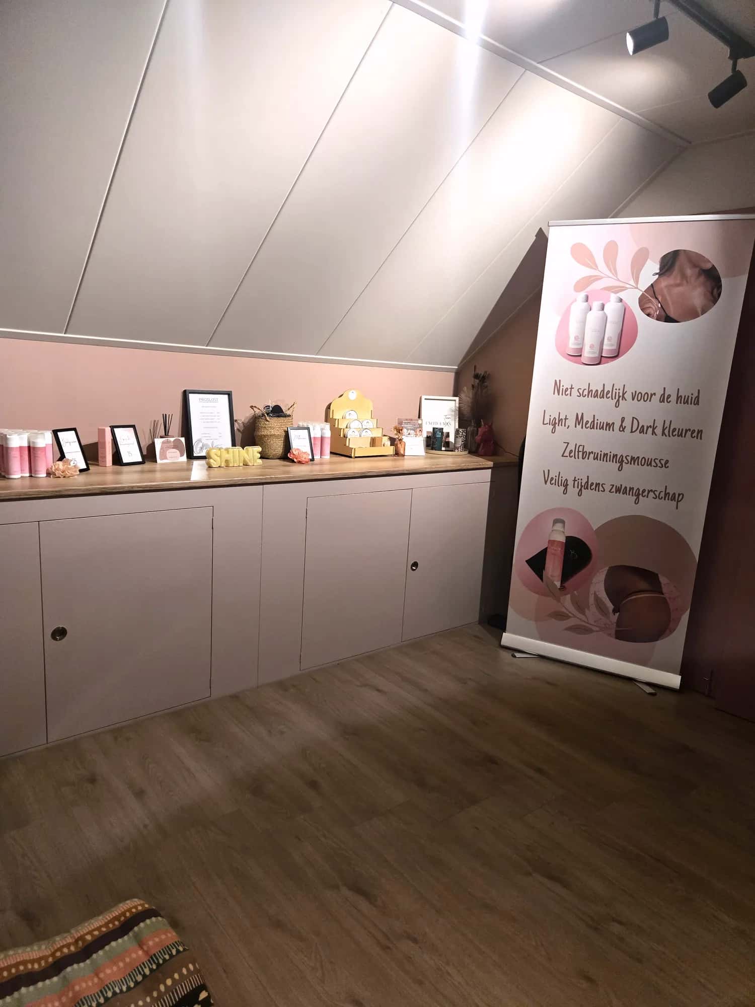 De GlowLine-studio in Wilp met oudroze muur en verzorgingsproducten