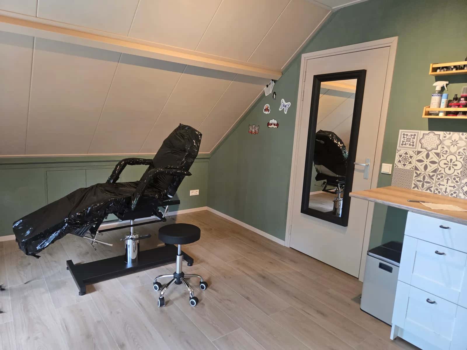 De tattoostudio van GlowLine in Wilp met behandelstoel, spiegel en groene wand